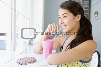 Young woman having cold drink in cafe