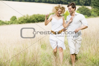 Couple Running Through Summer Field