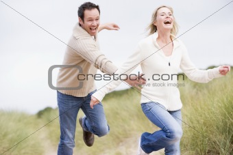 Couple chasing one another through dunes