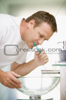 Man brushing teeth in bathroom