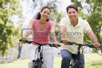 Couple riding bikes in countryside