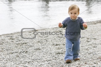 baby boy on empty pebble beach
