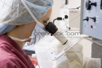 Embryologist using microscope