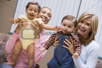 Two mothers holding young boy and girl