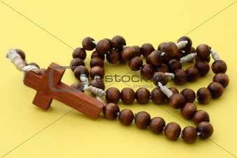 wooden rosary on yellow