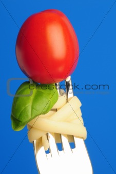 Fork with tomato, basil and pasta