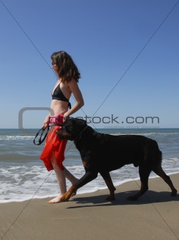 woman and rottweiler on the beach