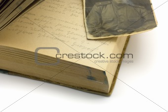 An old diary that is open with a old war photo on top