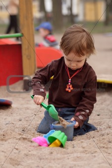 little girl playing at sand-box