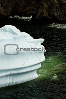 Iceberg outlined against the shoreline,