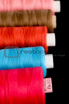 Spools of colorful thread in a row