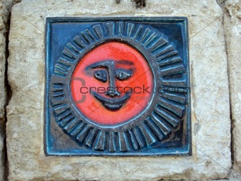 detail of a stone sun figure on wall