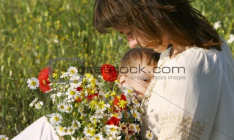 mother feeding baby in flowers