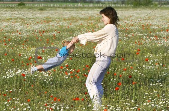 mother playing with her son in flowers