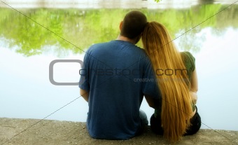 Couple sitting on lakeside