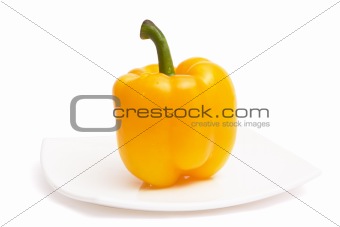 Yellow paprika on white ceramic plate