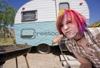 Girl in front of a trailer eating a hotdog