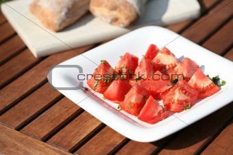 tomatoes with basil on white plate