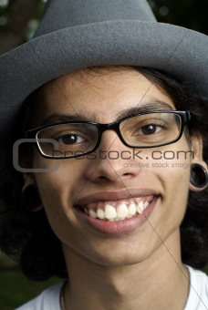 Smiling asian man with pierced ears and hat.