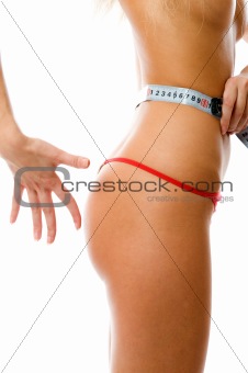 Closeup of 90x60x90. Sexy woman measuring her waist with a measuring tape