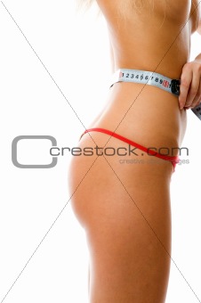 Closeup of 90x60x90. Sexy woman measuring her waist with a measuring tape