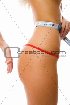 Sexy woman measuring her waist with a measuring tape