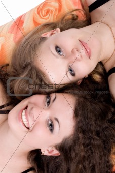 Portrait of the two beauty young women laying on a pillow 3