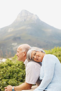 acation - A senior couple sitting against nature background